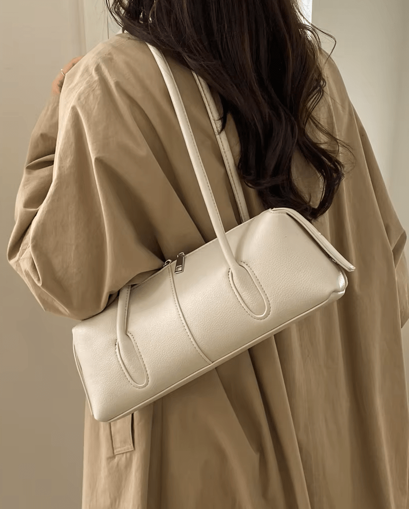 Mira Cylinder Shoulder Bag in cream – styled look